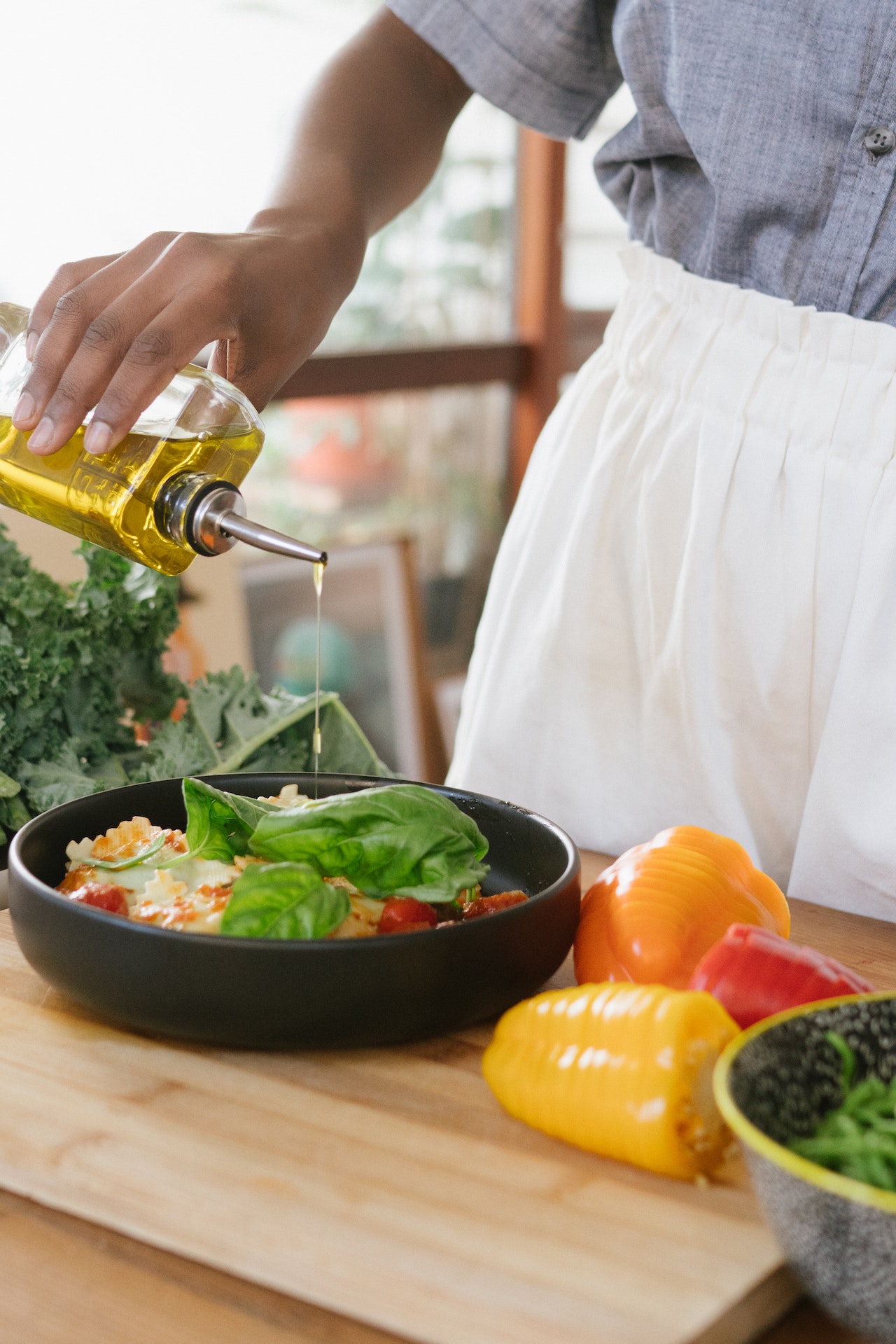 Woman puring olive oil in a salad